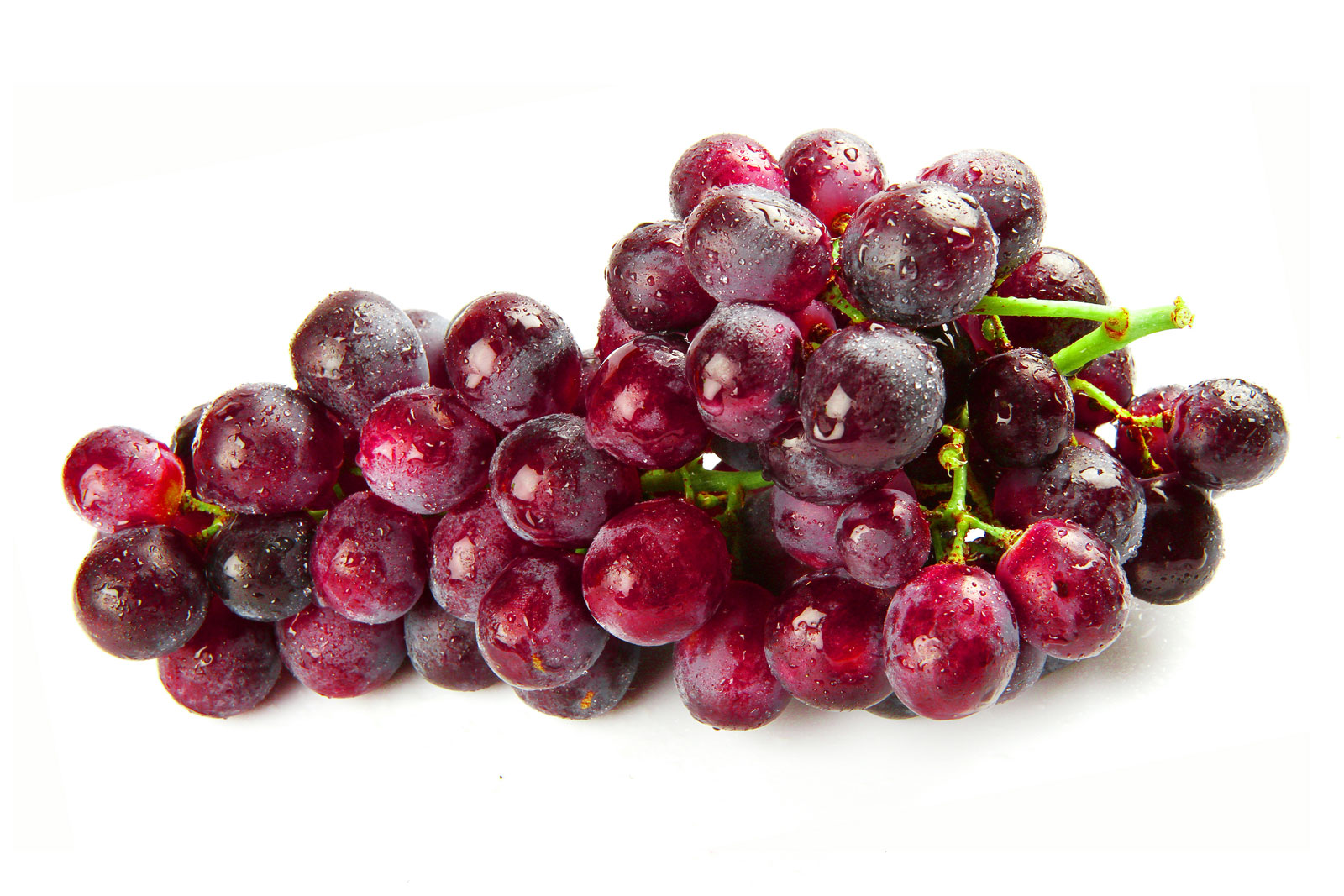 Foto de um cacho de uva vermelha sobre uma superfície branca