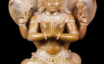 Escultura de Patanjali, com 4 braços. Há 5 cobras acima de sua cabeça com as caudas enrolados em suas pernas.