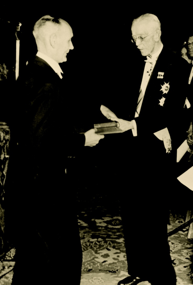 Foto em preto e branco do bacteriologista Gerhard Domagk recebendo, de um outro homem, o Nobel de Medicina em 1939.
