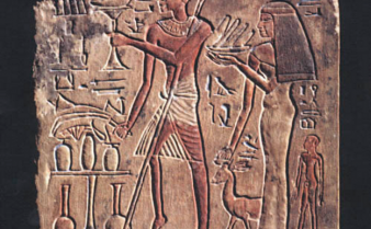 Desenho entalhado na parede com um homem ao centro e uma mulher ao lado. Há diversos hieróglifos ao redor deles.