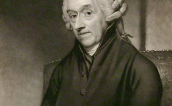 Pintura antiga e em preto e branco do médico inglês William Heberden. Ele está sentado em uma cadeira ao lado de diversos livros e usa uma peruca de época.