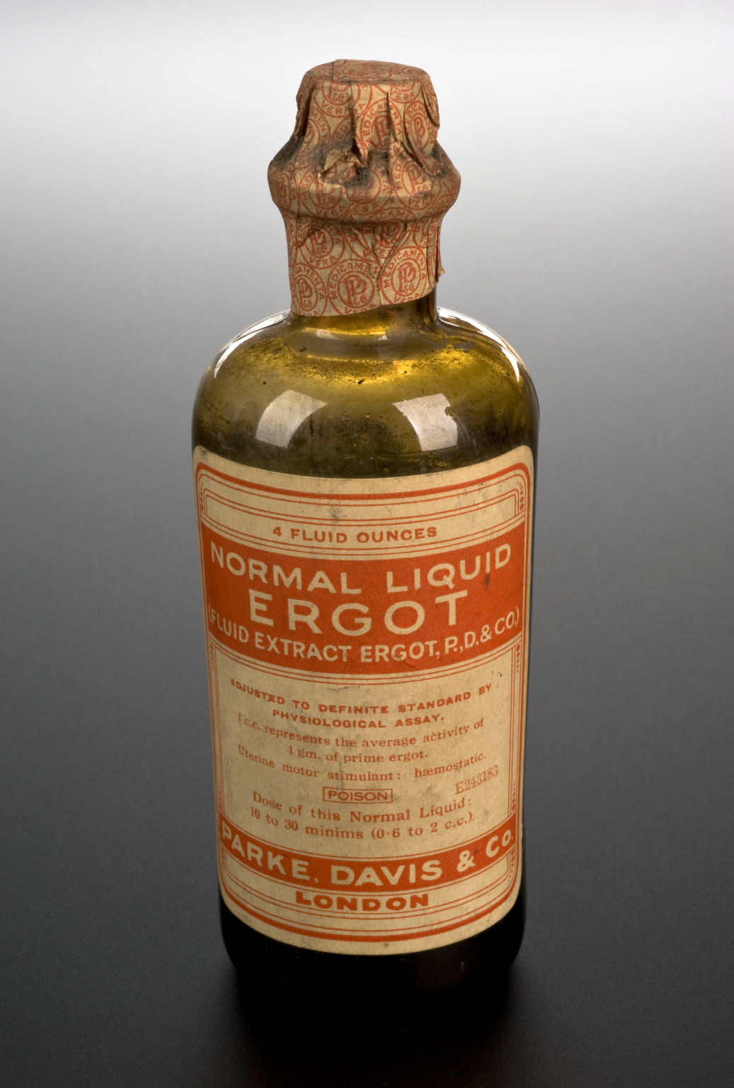 Foto de uma garrafa antiga na cor âmbar com Liquor Ergotae Purificatus.