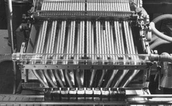 Foto em preto e branco de uma máquina de produção de medicamentos dos anos 1960.
